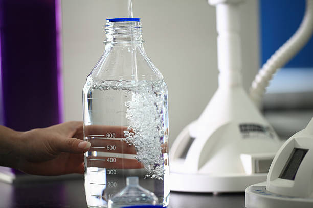 Close-up of a person's hand holding chemical bottle.