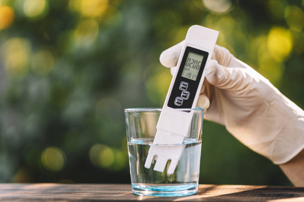 Water quality meter tester submerged in drinking glass